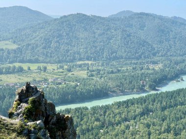 Dağın zirvesinde Şeytan 'ın parmağı. Parlak güneş, Altai, Rusya 'da Katun nehri ve ağaçlarla kaplı bir dağ vadisinin panoramik manzarası