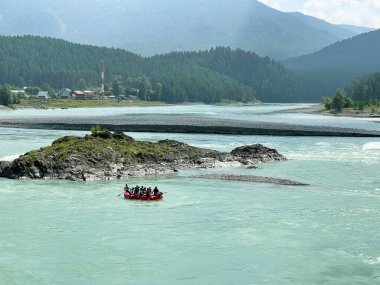 20 Ağustos 2021 - Katun nehri, Altai, Rusya: Büyük bir teknede turistler Katun nehrinin turkuaz sularında rafting yapıyorlar.