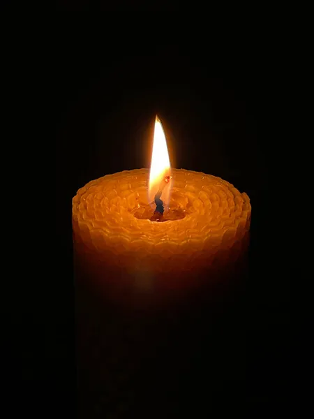 Воскова свічка горить у темряві — стокове фото
