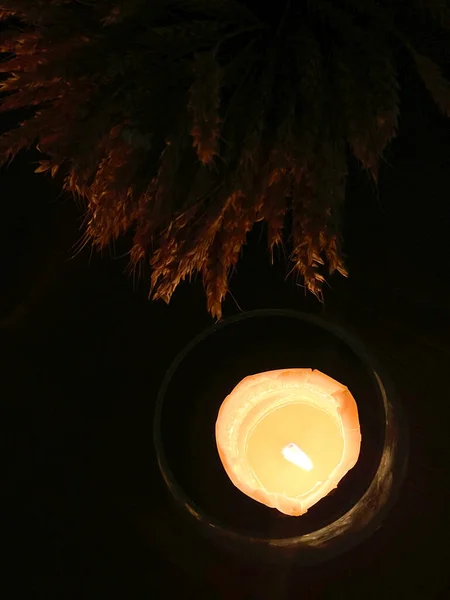 玻璃灯罩里的蜡烛在干枯的小穗旁的桌上燃着 圣诞餐桌装饰 — 图库照片