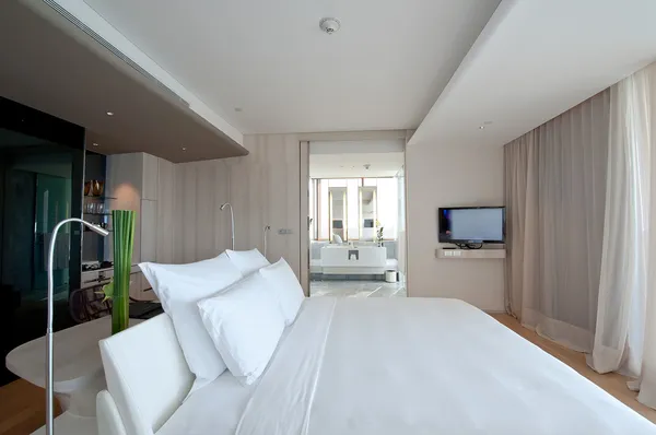 เตียงในห้องพักโรงแรม — ภาพถ่ายสต็อก