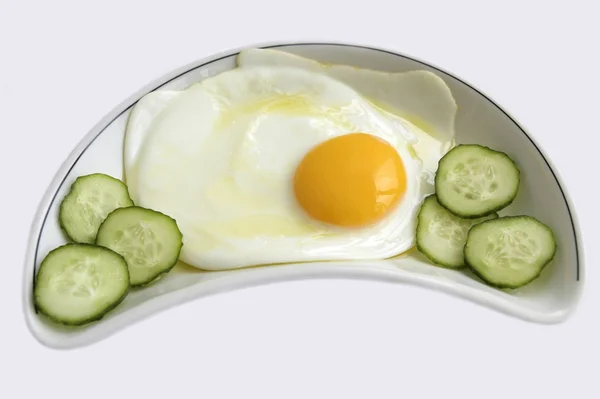 Жареное яйцо и огурец — стоковое фото