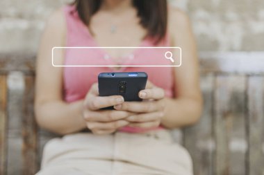 Milenyum kadını internet üzerinden internet üzerinden bilgi edinmek için telefon kullanıyor. Şehir parkında gündüz akıllı telefon kullanan kadın elleri. İnternet veri bilgi ağı konsepti taranıyor