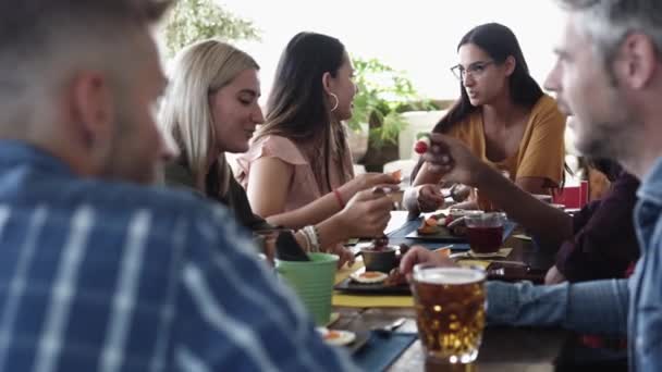 Lächelnde Gruppe diverser Freunde frühstückt und unterhält sich an der Kaffeebar — Stockvideo