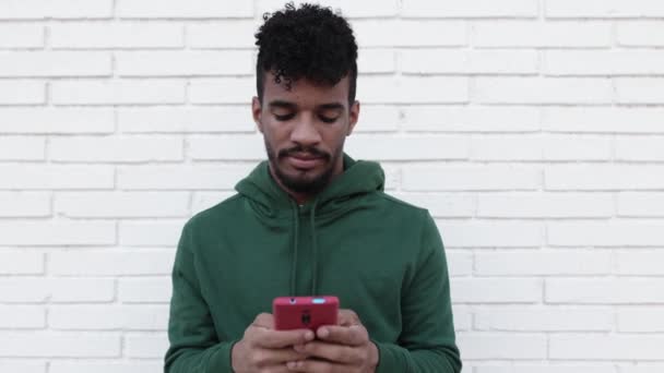 Retrato de jovem com penteado afro usando telefone celular ao ar livre — Vídeo de Stock