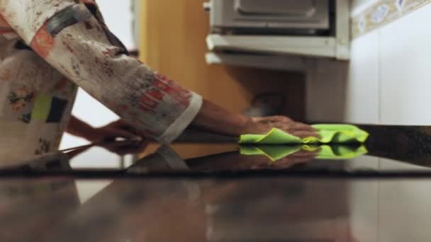 Senior kvinna hand rengöring kök elektrisk keramikhäll med mikrofiberduk — Stockvideo
