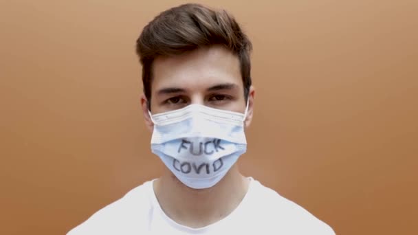 Retrato de un joven hispano mirando a la cámara con máscara protectora — Vídeos de Stock