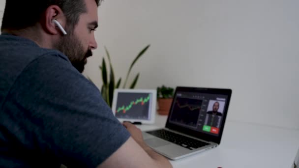 Молодий інвестор вивчає онлайн фондовий ринок через відеодзвінок з трейдером — стокове відео