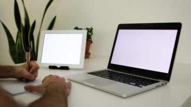 Ofis masasında boş ekranlı bilgisayar ve dijital tablet.