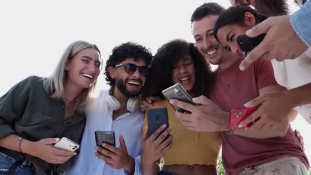 Happy diverse studenten vrienden lachen tijdens het gebruik van de smartphone — Stockvideo