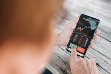Şifreli para almak için akıllı telefon yatırım uygulaması kullanan kadın