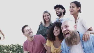 Bir grup mutlu çok ırklı insan dışarıda birlikte eğleniyor.