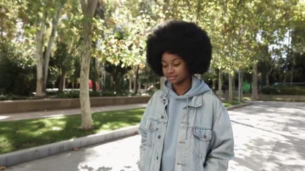 Fröhliche junge Afroamerikanerin läuft allein im Stadtpark — Stockvideo