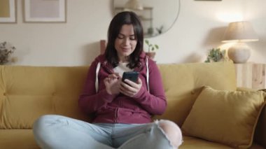 Şaşkın kadın telefonu kontrol ediyor ve iyi haberleri okuduktan sonra kutluyor.