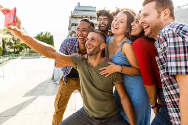 Çok ırklı genç arkadaşlar cep telefonlarıyla selfie çekiyorlar - Milenyum çok ırklı insanlar açık havada eğleniyorlar - arkadaşlık, birlik ve milenyum insanları konsepti