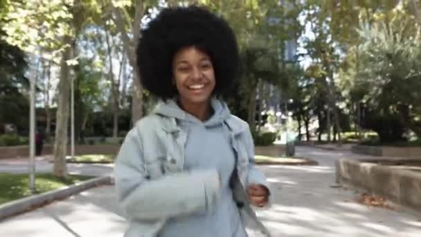 Kameraya bakarken koşan Afrikalı Amerikalı genç bir kadının ön görüntüsü. — Stok video