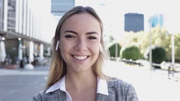 Fiatal üzletasszony mosolyog kamera szabadban a pénzügyi negyedben — Stock videók