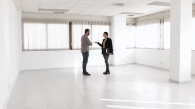 Man discussing with a real estate agent while visiting a new office space