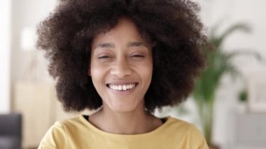 Kameraya gülümseyen Afrikalı genç bir kadın.