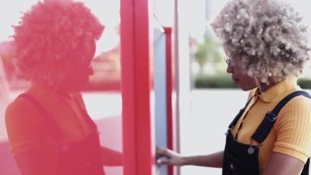 Африканская американка снимает деньги с банкомата — стоковое видео