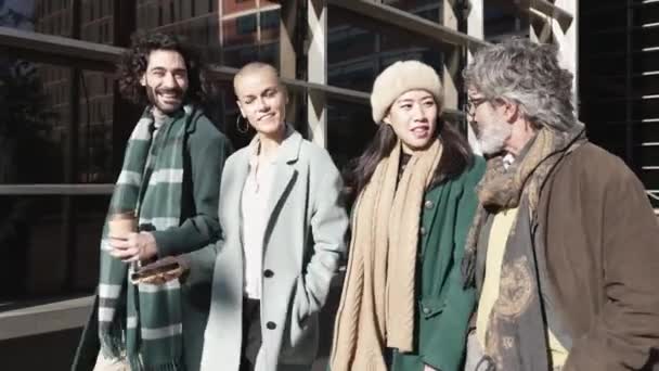 Grupp bestående av fyra olika affärsmän som pratar och går på stadens gata — Stockvideo