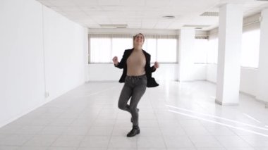 Ticari temsilci, bir anlaşma yaptıktan sonra boş bir ofiste dans ediyor.