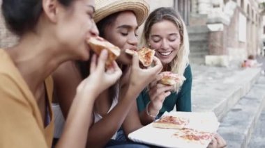 Pizza yiyen üç çok ırklı kadın İtalya 'da tatilin tadını çıkarıyor.
