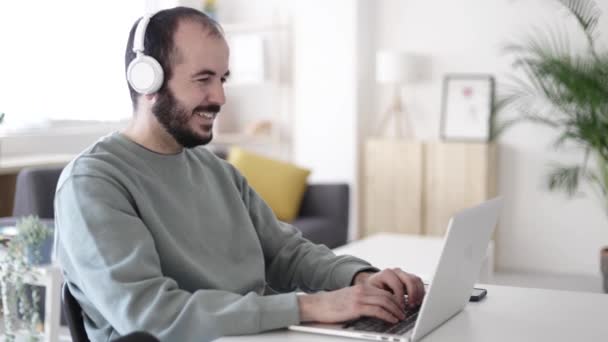 Freelance homem adulto médio ter uma chamada de vídeo no laptop trabalhando em casa — Vídeo de Stock