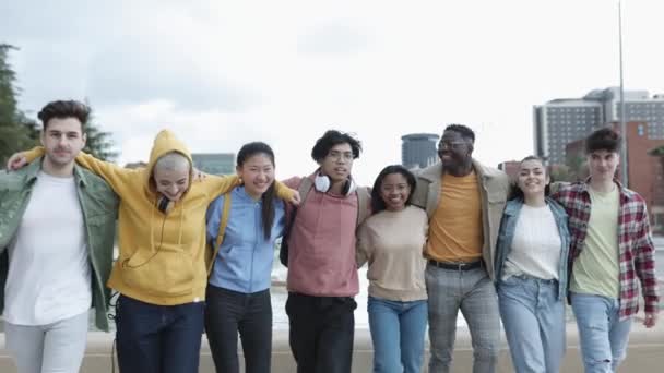 Groep van jonge multiraciale vrienden knuffelen elkaar tijdens het wandelen buiten — Stockvideo