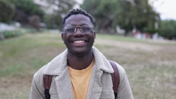 Dışarıda kameraya bakan gülümseyen Afrikalı genç bir öğrenci. — Stok video