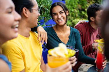 Genç mutlu arkadaşlar indirimli saatlerde çok renkli kokteyller içiyorlar.