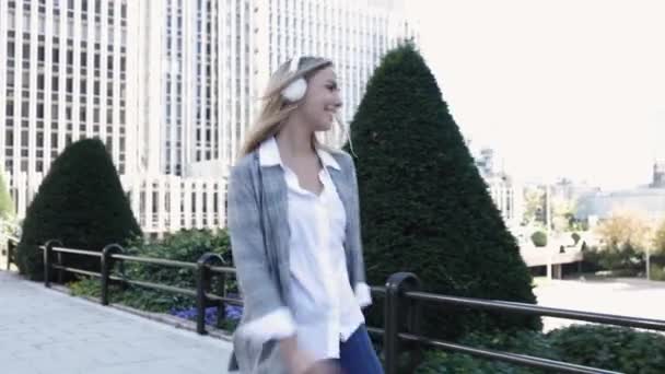 Молода бізнес-леді слухає музику з навушниками і танцює в фінансовому — стокове відео