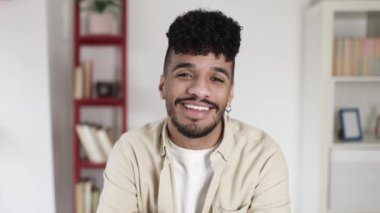 Latin kökenli Latin Amerikalı genç adam kameraya gülümsüyor.