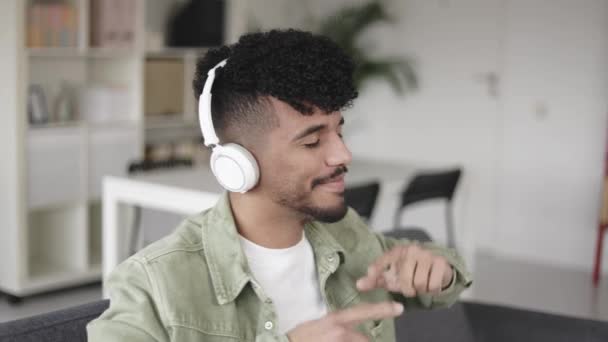 Genç Latin adam evde dans ederken kulaklıkla müzik dinliyor. — Stok video