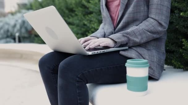 コーヒーを屋外で飲みながらノートパソコンで働くビジネス女性の手を閉じます — ストック動画