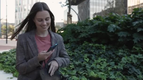 Uśmiechnięta młoda kobieta biznesu profesjonalne rozmowy telefoniczne na ulicy miasta — Wideo stockowe