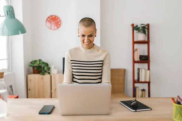 Sonriendo mujer adulta medio usando el ordenador portátil en la oficina en casa — Foto de Stock