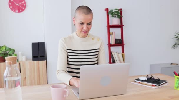 Uśmiechnięta dorosła kobieta korzystająca z laptopa w biurze — Wideo stockowe