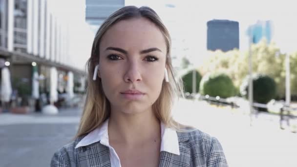 Seriöse junge Geschäftsfrau blickt im Finanzviertel in die Kamera — Stockvideo