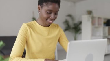 Gülümseyen Afro-Amerikan kadın üniversite sınavlarına hazırlanıyor.