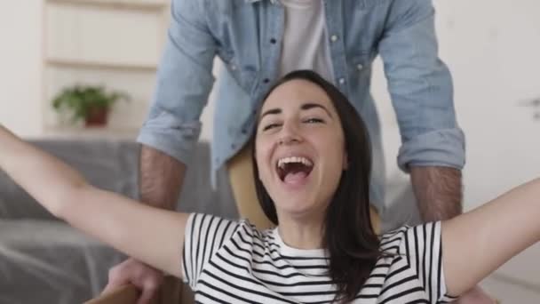 Glada par som har kul när du packar upp på flyttdagen i ny lägenhet — Stockvideo