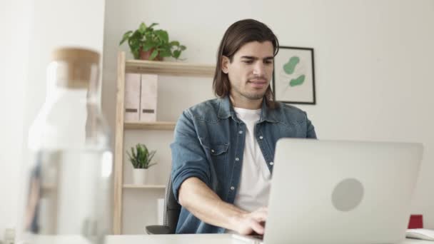 Jovem freelancer homem trabalhando no computador portátil do escritório em casa — Vídeo de Stock
