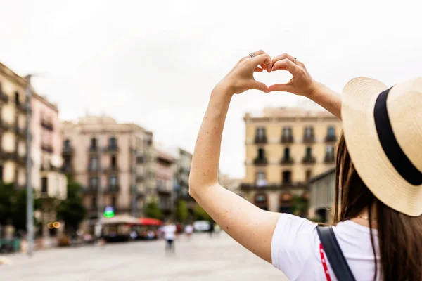 Giovane donna disegno a forma di cuore con le mani nella città di Barcellona — Foto Stock