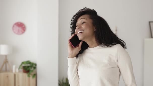 兴奋的年轻女人在家里用智能手机说话 — 图库视频影像