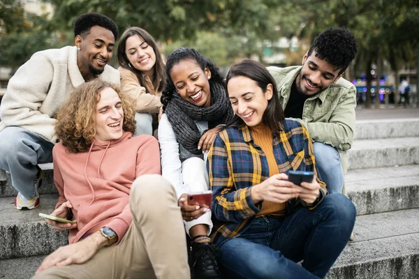 Groupe multiculturel de jeunes amis branchés utilisant le téléphone portable dans la rue de la ville — Photo