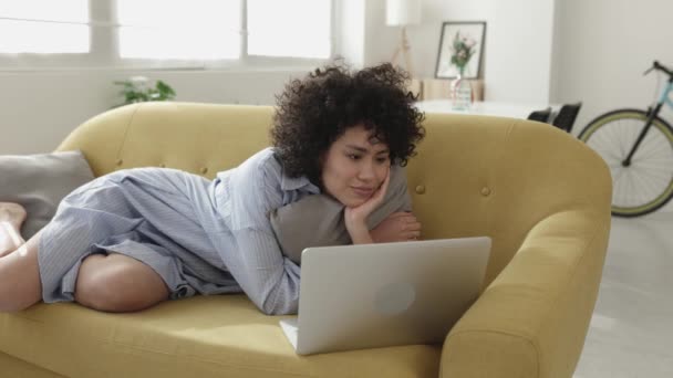 Joven mujer adulta viendo películas en el ordenador portátil en casa — Vídeos de Stock