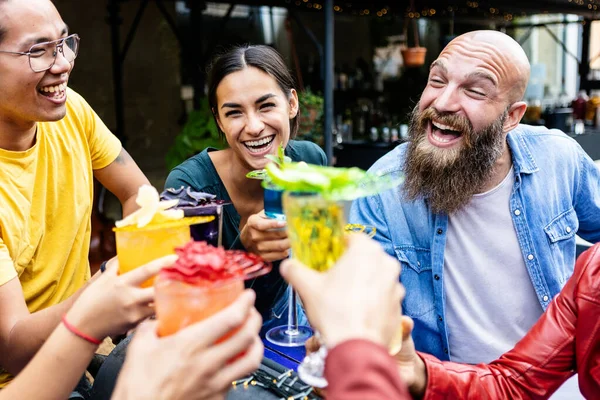 Felices amigos divirtiéndose en la fiesta de verano bebiendo y brindando cóctel de moda — Foto de Stock