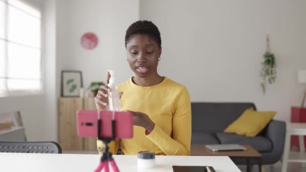 Fiatal afrikai befolyásoló nő streaming online szépségápolási termék a bőr — Stock videók