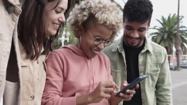 Jóvenes multirraciales se divierten usando la aplicación móvil de redes sociales — Vídeo de stock