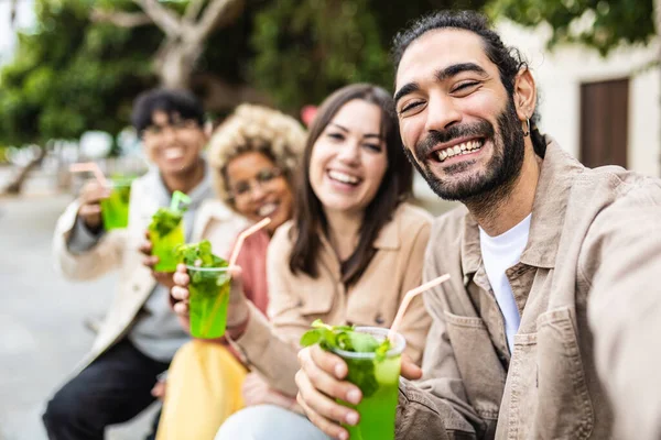 Happy multiracial friends drinking cocktails in city street — Stock Photo, Image